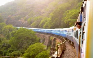 Vibrant train journey through lush green hills during sunset or sunrise.