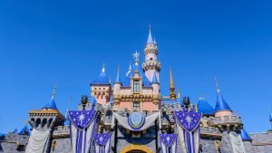 Colorful Disney castle with blue turrets and royal banners at Disneyland.