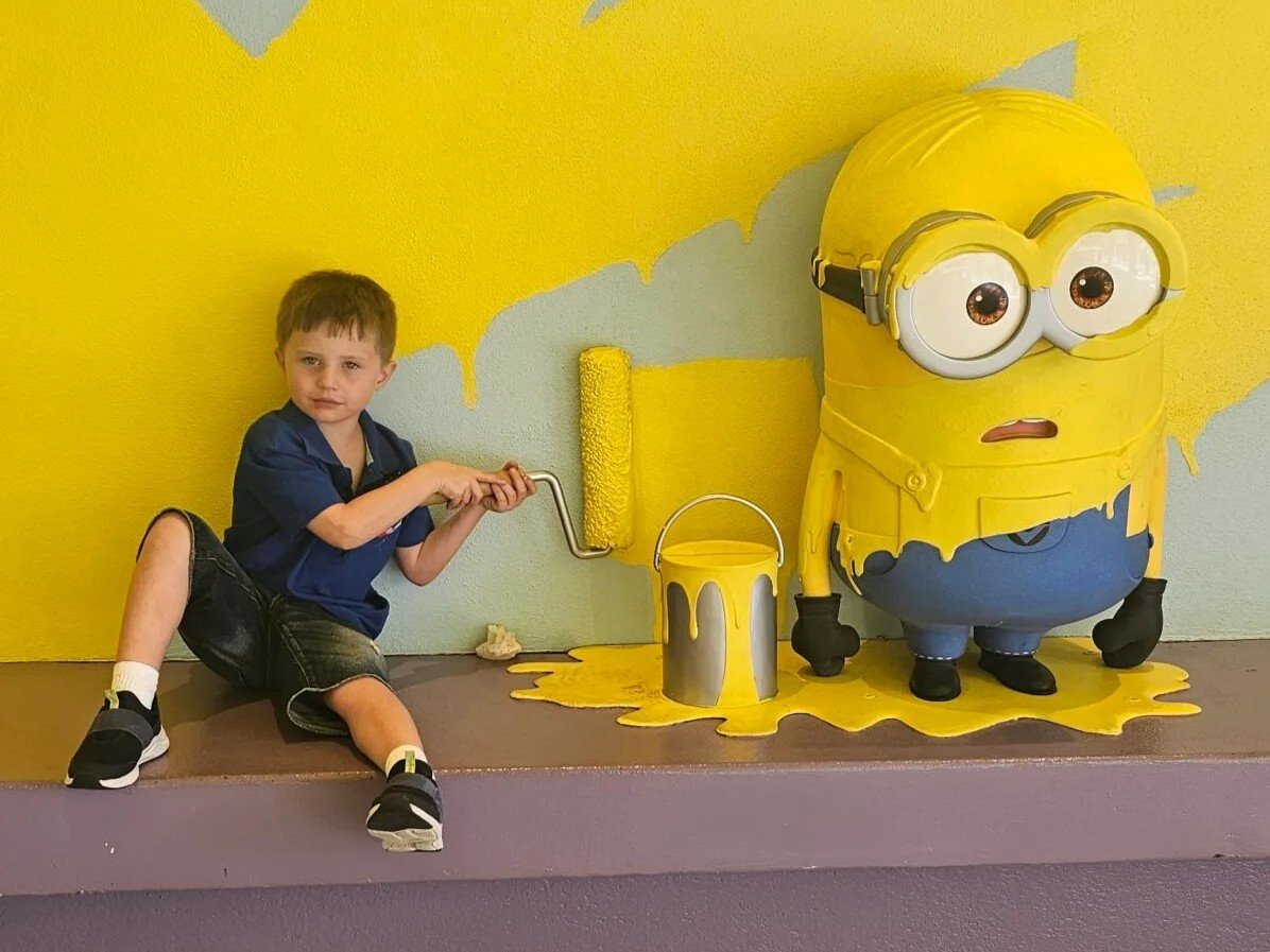 Painting with a Minion character and a young boy engaging in creative art activity at Flying E Travel.